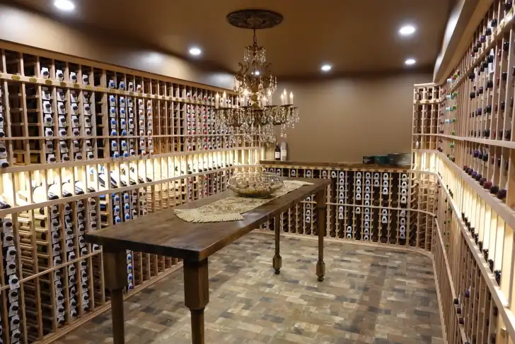 Elegant wine cellar with wooden wine racks, a chandelier, and a long wooden table