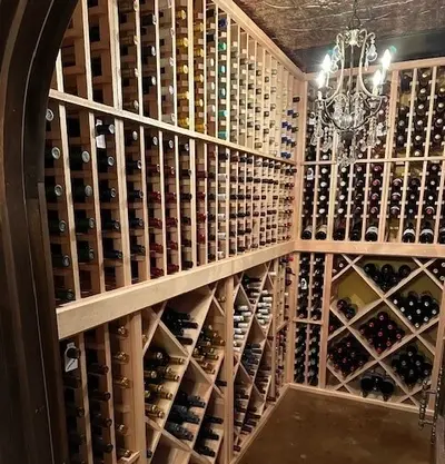 Well-lit wine cellar with diamond-shaped wine racks filled with bottles